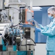 Scientist with hair cover working with complicated machinery