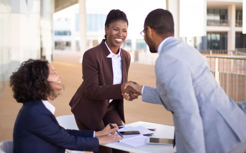 business professionals shake hands at the end of a meeting
