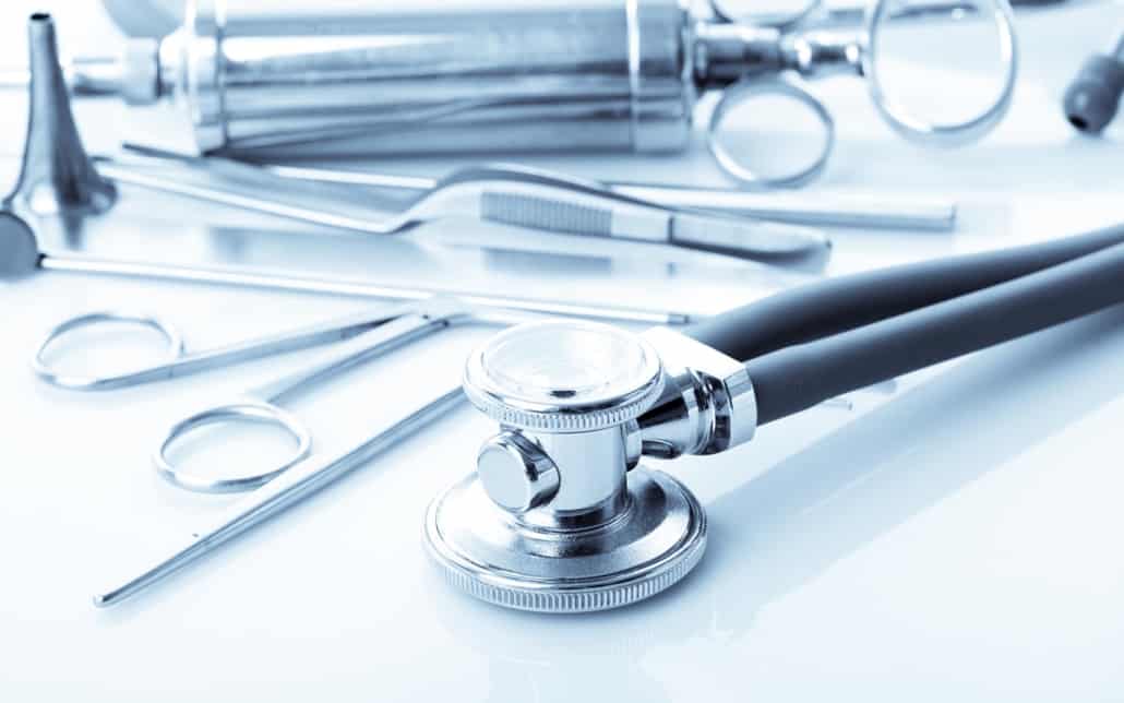 Image focused on a stethoscope with other medical accessories in the background.