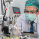 Engineer man wearing hygienic mask to protect coronavirus holding computer tablet checking and inspection machine