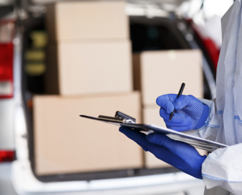 Close up of man in protective suit checking delivery in list